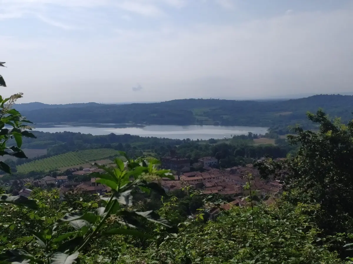 Il Lago di Candia visto da un pendio verde sopra un paese